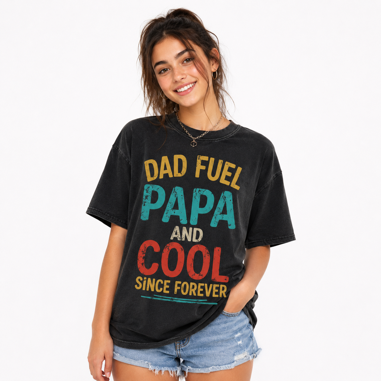 Woman wearing a washed black oversized graphic T-shirt with multicolor slogan text and denim shorts