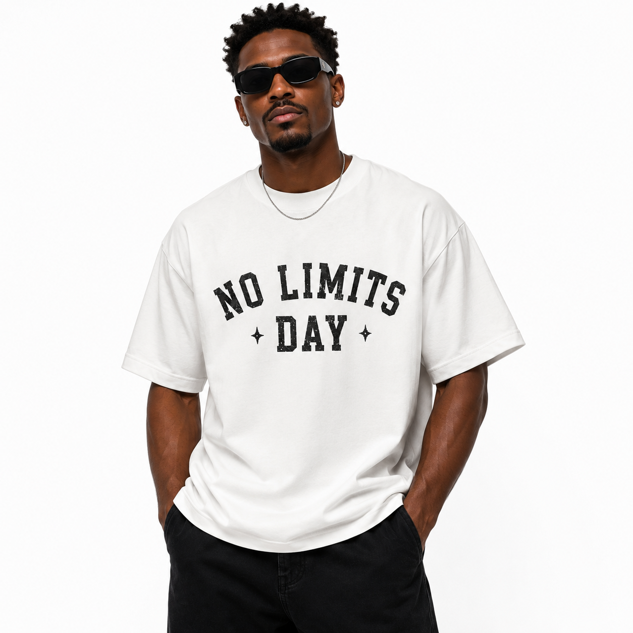 Man wearing a white oversized graphic T-shirt with "NO LIMITS DAY" black print on the front