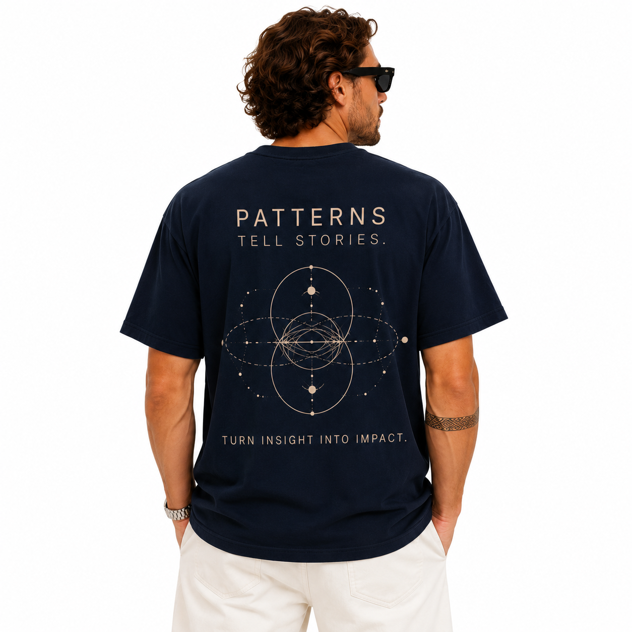 Back view of a man wearing a navy T-shirt with geometric graphic print and slogan text on the back