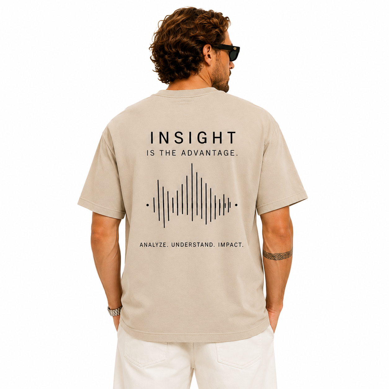 Back view of a beige oversized T-shirt with Insight slogan text and soundwave graphic print on a male model.