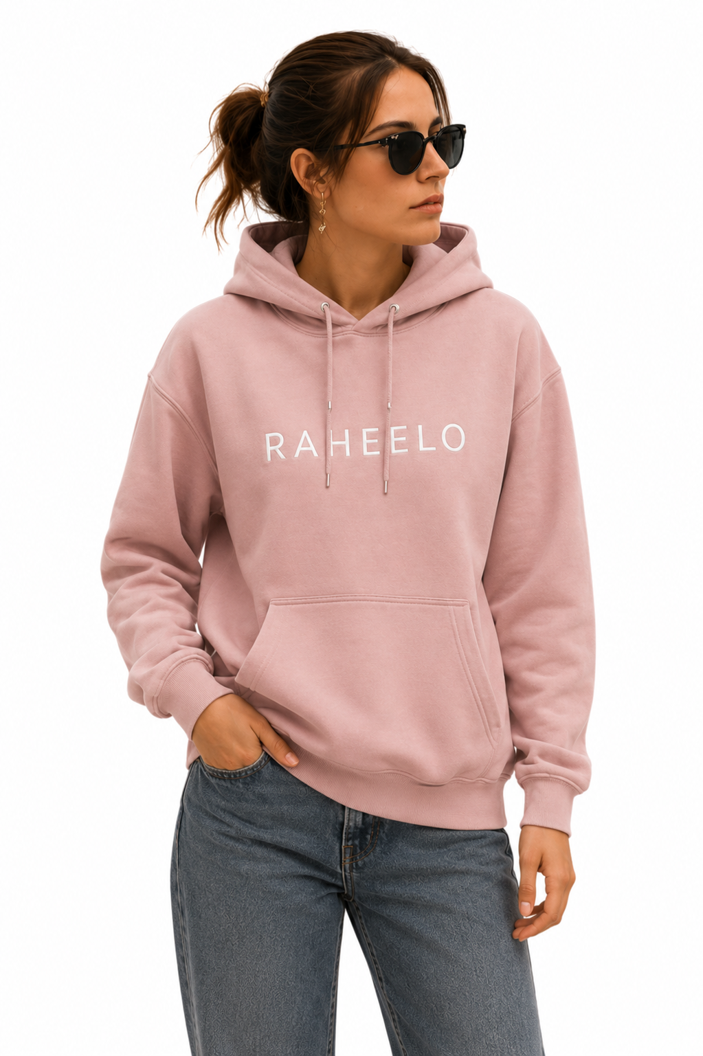 Woman wearing a dusty pink Raheelo pullover hoodie with white logo, drawstrings and front kangaroo pocket.